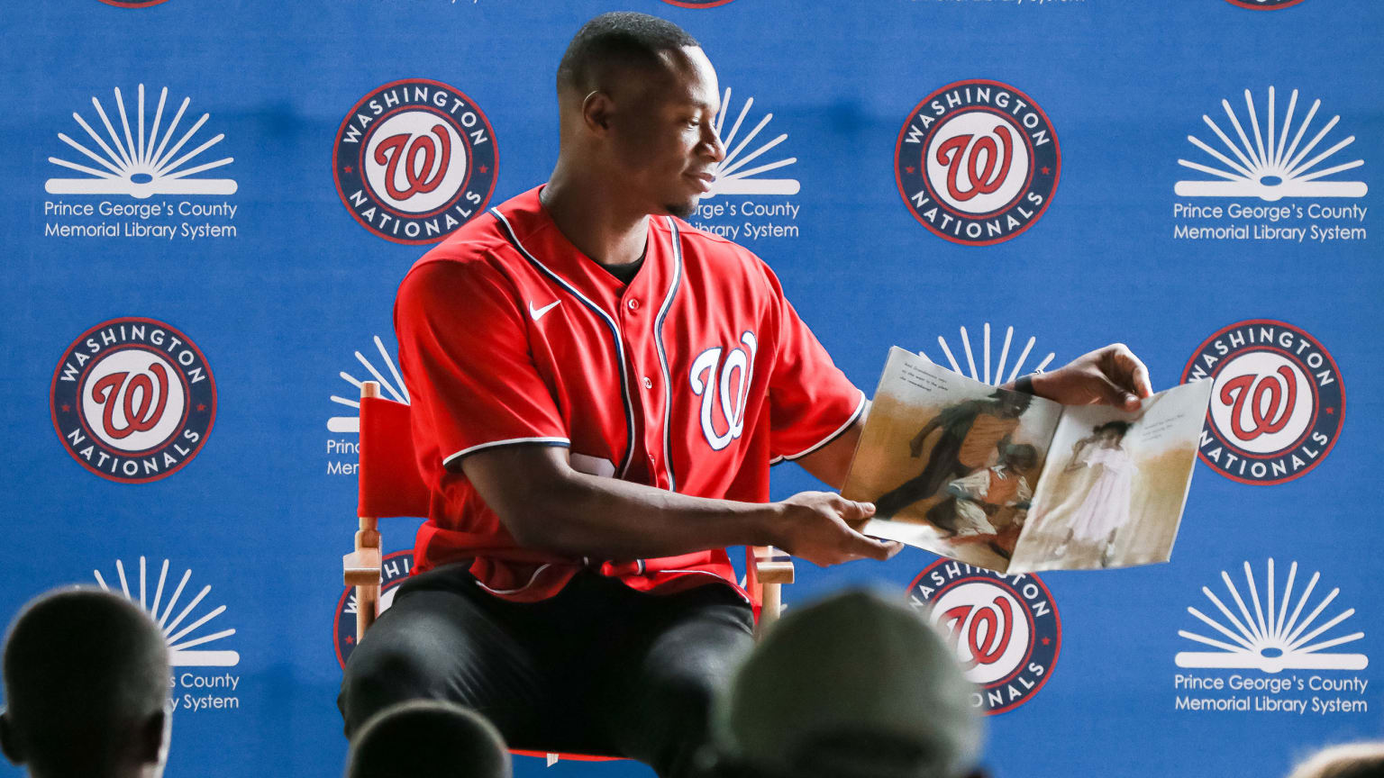 picture of baseball player reading a picture book to children